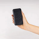 Biosignals PRO hub held in a hand, showing its compact wearable size